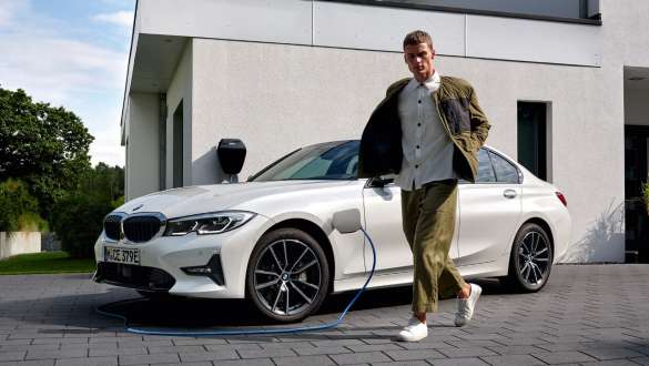 Plug-in hybrid BMW 3 Series Sedan 2021 G20 three-quarter front view charging Plug-in hybrid BMW 3 Series Sedan 2021 G20 three-quarter front view charging with model