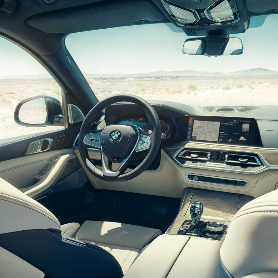 BMW Live Cockpit Professional BMW Live Cockpit Professional: View from the back into the first row of seats with a view of the steering wheel and instrument cluster