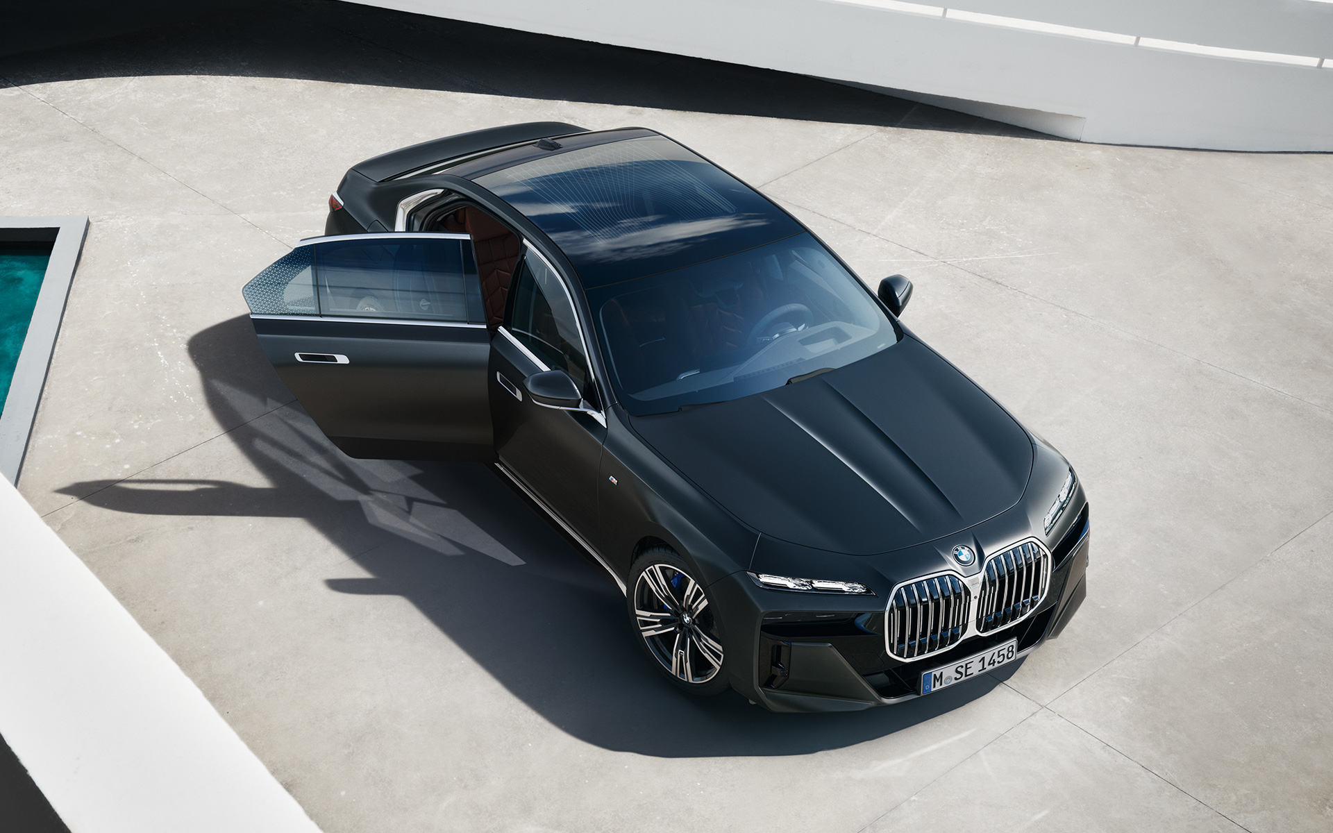Bird's eye view BMW 7 Series Sedan G70 ICE 740i M sports package Frozen Deep Grey metallic BMW 7 Series Sedan G70 ICE 740i M sports package Frozen Deep Grey metallic bird's eye view with open passenger door