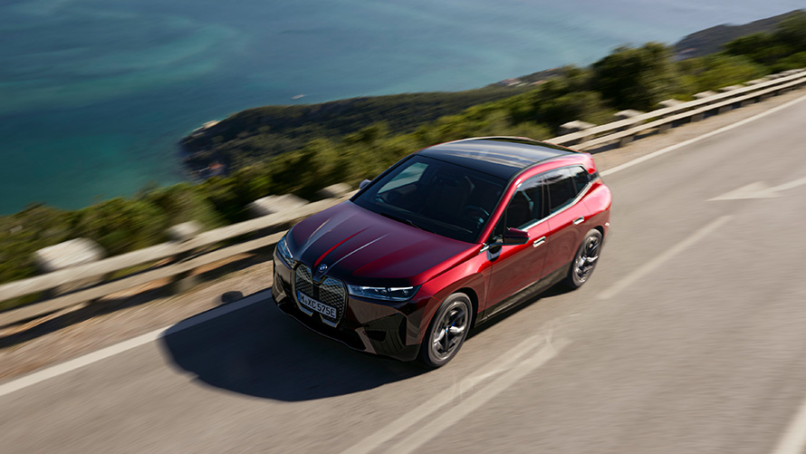 BMW iX i20 electric SUV BMW iX xDrive50 performance BMW iX i20 2021 electric SUV BMW iX xDrive50 Aventurin Red driving on a street performance