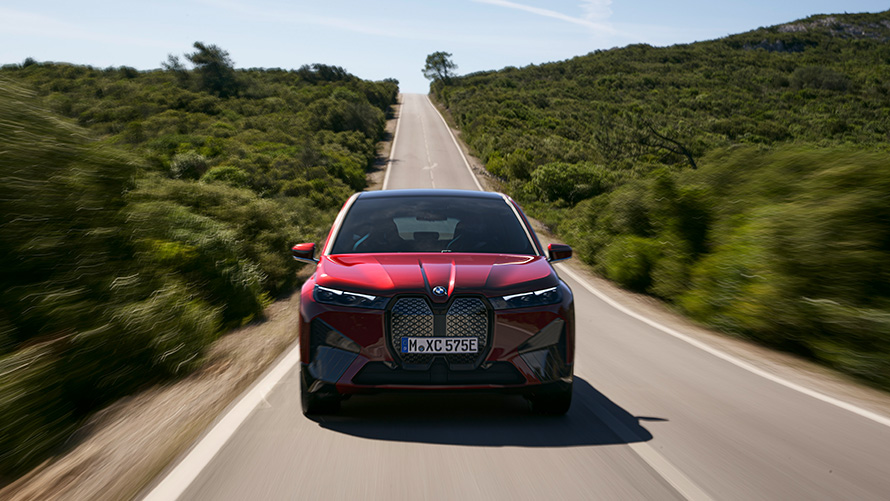 BMW iX i20 electric SUV BMW iX xDrive50 range BMW iX i20 2021 electric SUV BMW iX xDrive50 Aventurin Red driving on a street range