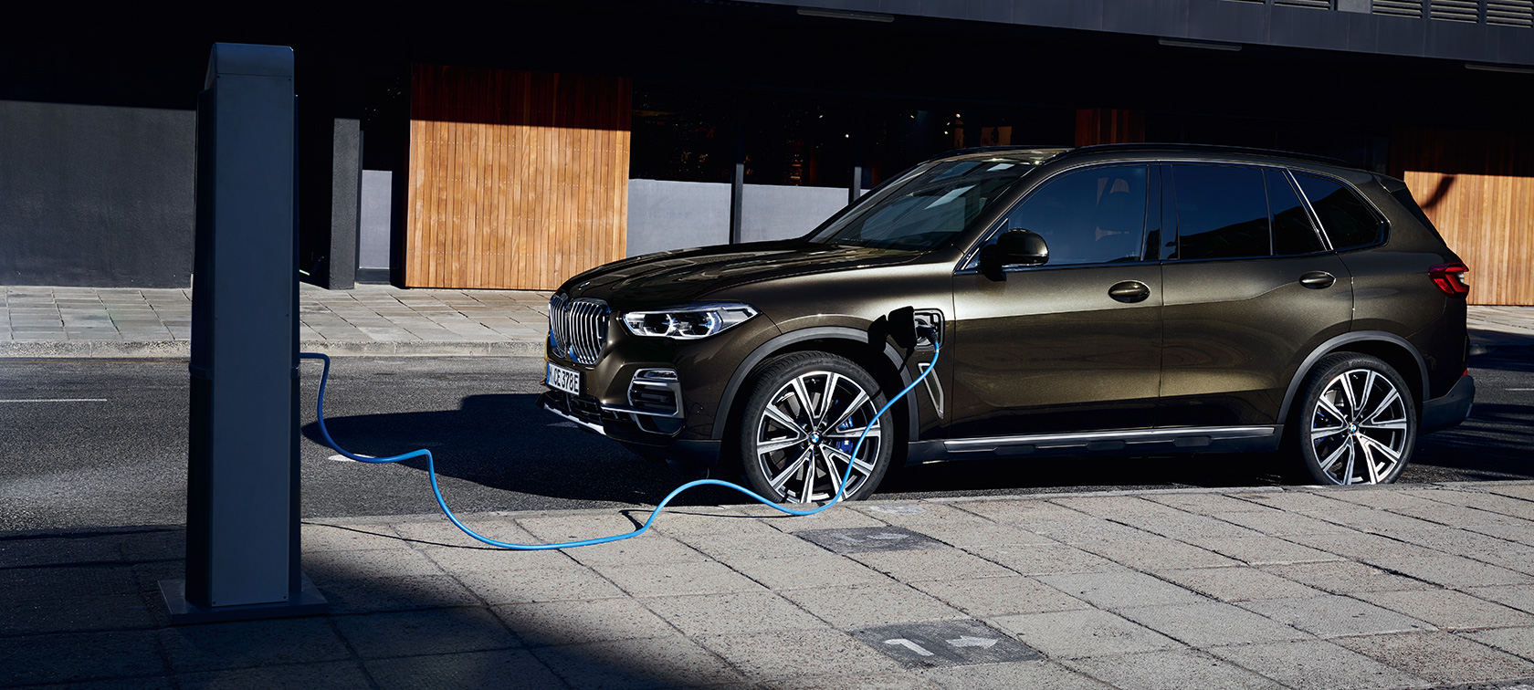 Plug-in hybrid BMW X5 xDrive45e G05 three-quarter side view Plug-in hybrid BMW X5 xDrive45e G05 three-quarter side view charging
