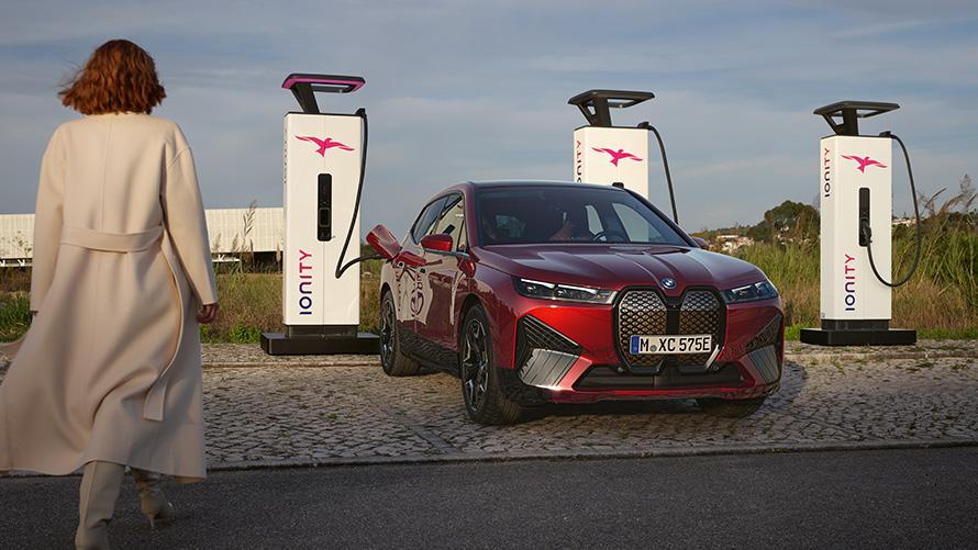 BMW Charging Solutions BMW Special Sales Sustainability Hub Overview BMW Special Sales Sustainability Hub Overview BMW Charging Solutions BMW vehicle at charging station with woman in foreground