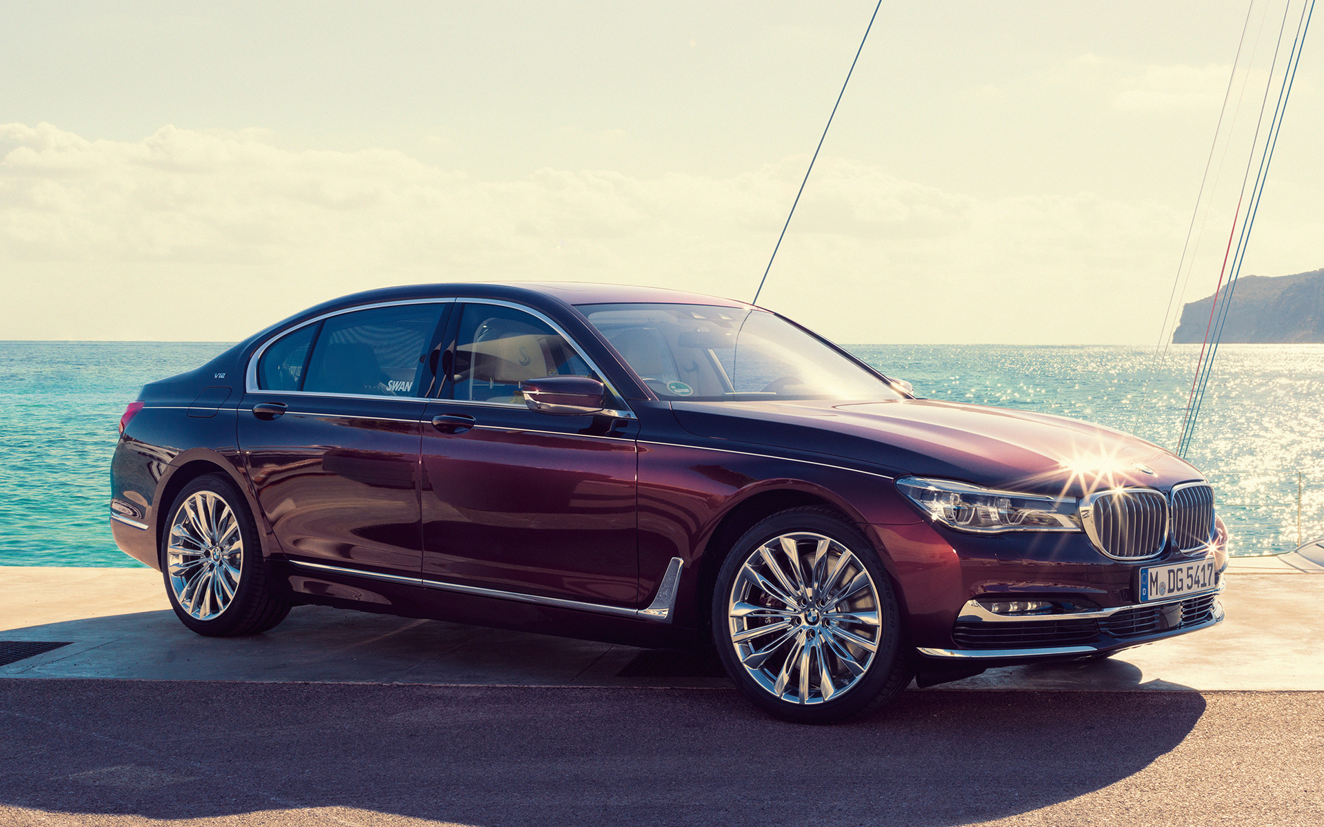 BMW Individual M760Li inspired by Nautor’s Swan G12 2017 in front of sailing yacht BMW Individual M760Li inspired by Nautor’s Swan G12 2017 three-quarter side view standing at pier in front of sailing yacht in bay