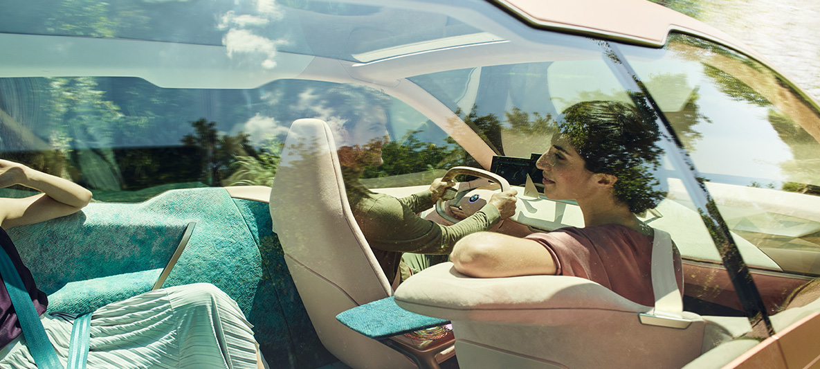 Woman on passenger’s seat in the BMW Vision iNEXT Dark-haired woman in passenger’s seat in the BMW Vision iNEXT turns to back seats