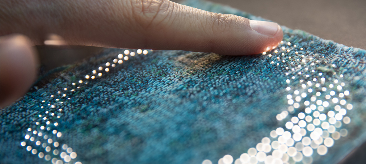 Fabric with lighting circle Finger touches green fabric with lighting circle