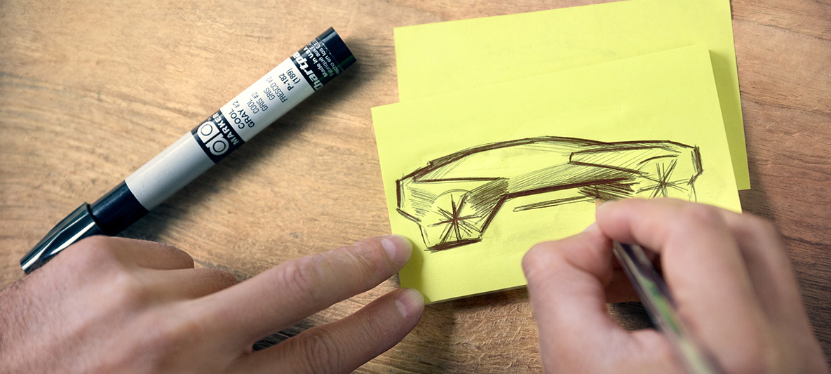 Sketch of the BMW Vision iNEXT Hands drawing sketches of the BMW Vision iNEXT on post-it