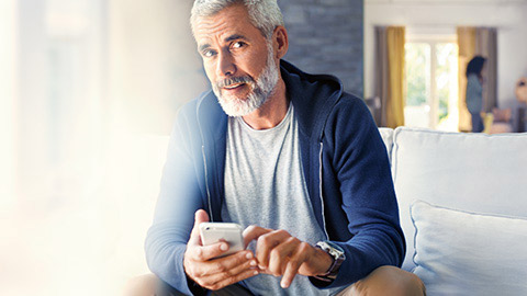BMW ConnectedDrive BMW Store man sitting with smartphone in his hands
