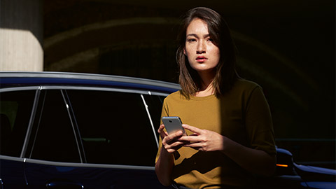 BMW ConnectedDrive overview BMW ConnectedDrive digital services overview woman with smartphone in front of BMW