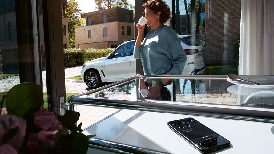 Remote Software Upgrade Woman enjoys coffee at home while Remote Software Upgrade is running on smartphone