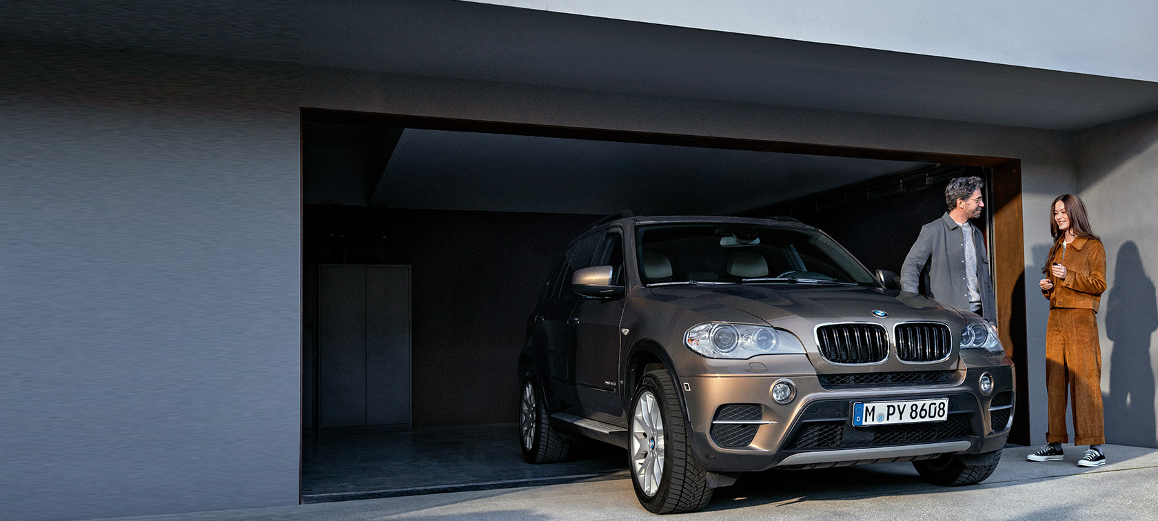 BMW Value Service BMW Value Service man and woman in front of garage with BMW X5