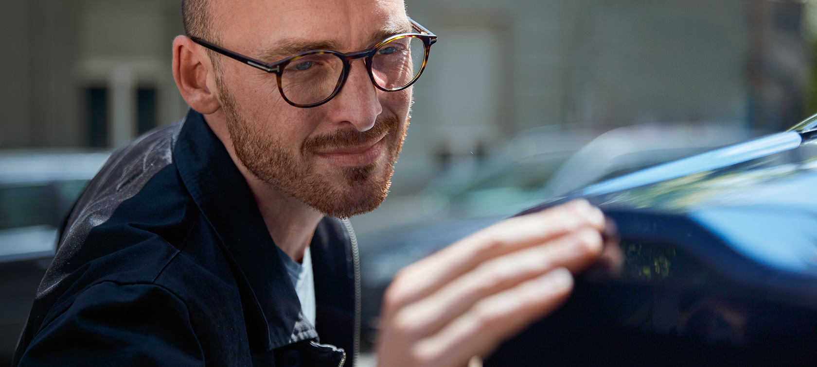 A man sensitively touching his BMW. A man sensitively touching his BMW.
