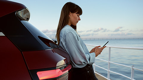 Woman using My BMW App on smartphone Woman using My BMW App from BMW ConnectedDrive on smartphone